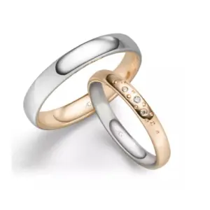 Zwei Eheringe, einer aus Silber, der andere aus Gold mit Diamanten, symbolisieren ewige Liebe und Verbundenheit.