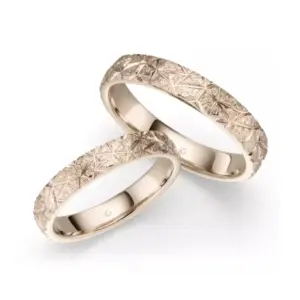 Zwei stilvolle Eheringe aus Gold mit geometrischem Muster, ideal für Hochzeiten und Jubiläen.