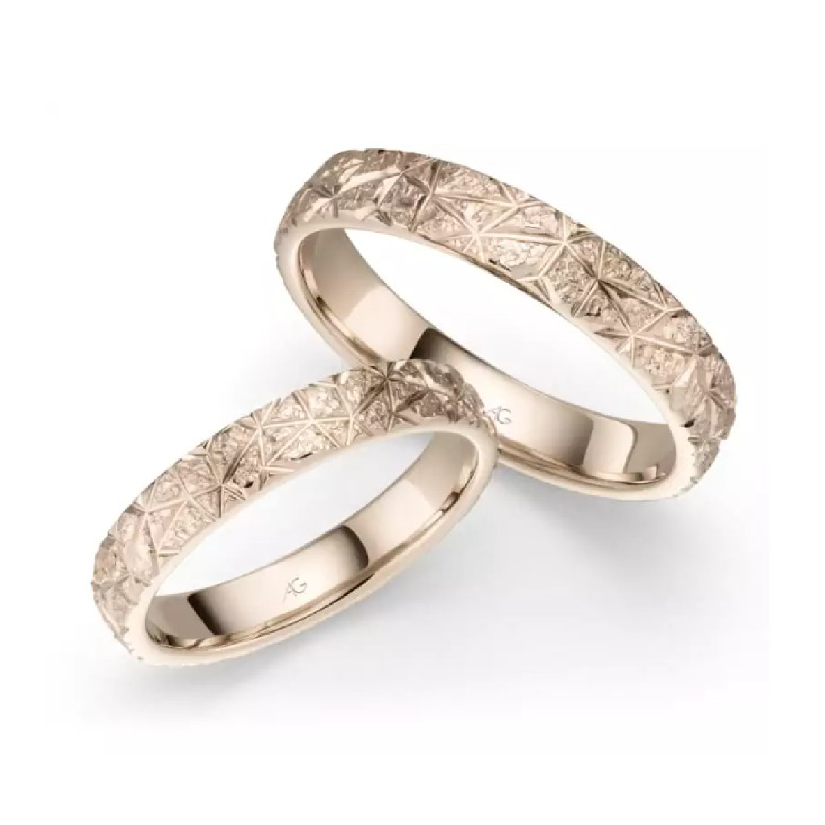 Zwei stilvolle Eheringe aus Gold mit geometrischem Muster, ideal für Hochzeiten und Jubiläen.